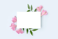Floral frame made of alstroemeria flower on a blue background. Paper card mockup. Holidays concept for Mothers Day.
