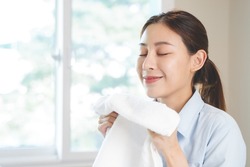 Asian housewife smelling freshness scent of clean clothes