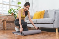 sporty young woman prepare yoga mat to exercise  at home