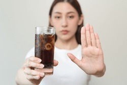 Limits sugar diet in food concepts. Young woman showing bad hand symbol to soft drink soda that have high sugar.