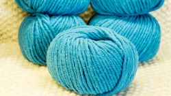 Wool in a tangle in turquoise on a knitted background