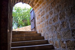 Stone steps lead up to the arched entrance of the basement