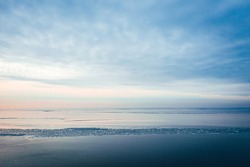 Aerial view on frozen seawater at a beautiful sunset against a blue sky, winter by the sea 