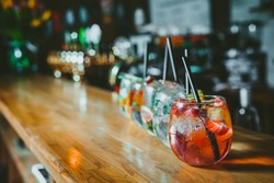 Alcoholic cocktail row on bar table, colorful party drinks 