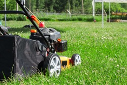 The lawn mower with a grass collector is ready to work