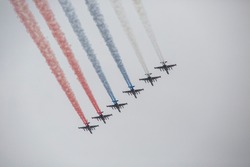 Military fighters on the Naval Parade. Planes leave a trail of the color of the Russian flag