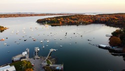 Aerial view of maine coastal harbor - drone picture of lobster boats with the ocean inside a marina  sunset - kennebunk maine round pond maine coastal maine