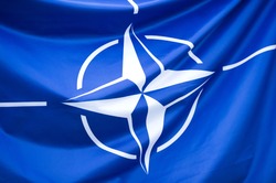 NATO Flag - Close-up photo of waving original and simple NATO flag. NATO is an intergovernmental military alliance based on the North Atlantic Treaty which was signed on 4 April 1949.