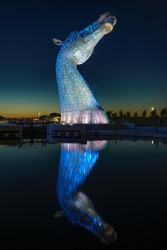The Kelpies Horse statue lit up at night at The Helix Park in Falkirk, Scotland