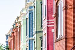 Row of colorful red green and blue painted brick residential townhouses homes houses architecture exterior in Washington DC Capitol Hill neighborhood district