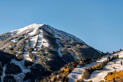Aspen, Colorado buttermilk or highlands ski slope hill peak in rocky mountains view on sunny day with snow on yellow foliage autumn trees