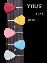 colorful red pink yellow blue white picks on guitar fingerboard isolated on black for music background