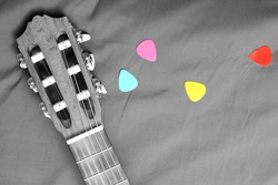 acoustic guitar and colorful picks on B&W fabric process for background