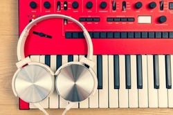 white headphone on red synthesizer keyboard. music concept