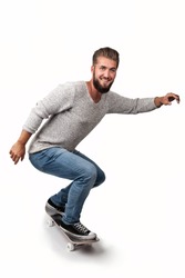 Attractive young man with a beard has fun on a skate board