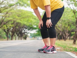 Overweight woman feeling tired while running in the park. Weight loss concept