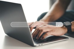 Man using a laptop computer to Searching for information with the Search bar, Web browser, Data Search, Search Engine, Technology Concept