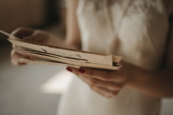 A girl holding a stack of old letters.