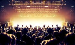 Raised hands in front of a concert stage for a festive crowd