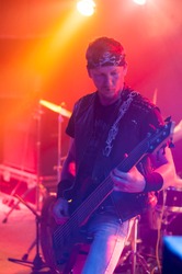 Guitarist playing on stage. Dark background, smoke, spotlights