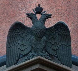 Bronze sculpture of the Russian double-headed eagle on a background of red granite