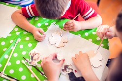 Children hands making artworks with wood and paint crafts. workplace and handcraft Decoupage