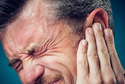 A man feeling strong ear pain. Close up. People, healthcare and medicine concept.