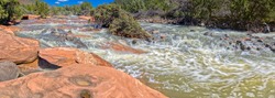 A section of Dry Beaver Creek south of Sedona AZ with red sandstone boulders and rapidly flowing water. Located in Woods Canyon.