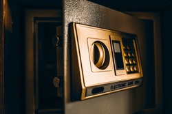Golden safe box with electronic lock is kept open.