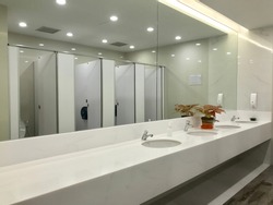 Row of wash sink with big mirror in public toilet