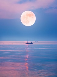 local fishing boat in the quiet sea on the full moon night and romantic atmosphere