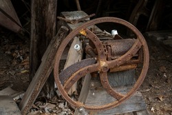 An old rusted iron wheel placed against other vintage objects at an historical heritage listed homestead
