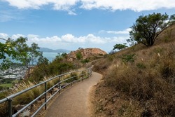 A tourist walking track along the side of a mountain of pink granite with city views