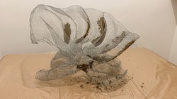 Flower sculpture being made with wire mesh and gray cement.