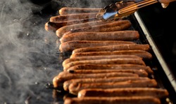 Sausages sizzling on hot barbecue