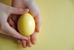 Yellow Easter egg in the Palm of your hand. Easter holiday