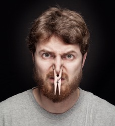 Bad smell concept - peg on male nostrils over black