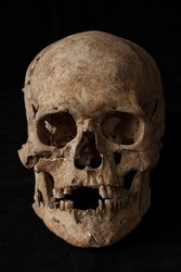 ancient human skull on black background
