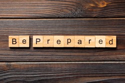 BE PREPARED word written on wood block. BE PREPARED text on wooden table for your desing, concept.