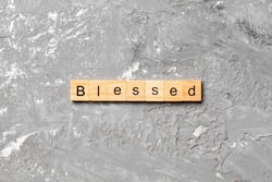 Blessed word written on wood block. Blessed text on table, concept.