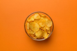 Potato chips on bowl isolated on colored background. Delicious crispy potato chips in bowl. Space for text. Top view.