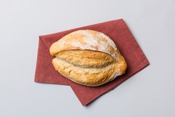 Freshly baked delicious french bread with napkin on rustic table top view. Healthy white bread loaf.
