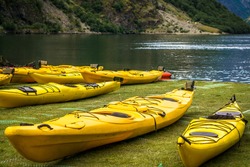 Yellow kayaks on the fjord in Norway, Gudvangen. Kayaks on fjord shore in norwegian tourist destination. Travel, holidays and active lifestyle concept in Sognefjord, Scandinavia. Rental centre.