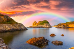 The colorful rainbow, which is born after the rain, provides a spectacular landscape. Colorful rainbow view that appears among the pink clouds. Skyline of sunrise on the beach. Kas, Antalya.