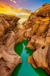 the river flowing through the valley of huge red rocks. Canyon view at sunset. extraordinary natural scenery. Nature landscape in the canyon. View of the stream flowing from the valley.