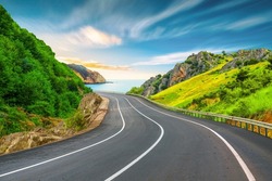 Beautiful nature scenery to travel on the colorful road landscape among the mountains by the sea. Traveling in the beach highway landscape during summer vacation. Turkey journey in green nature road.