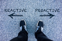 Reactive vs Proactive text on asphalt ground