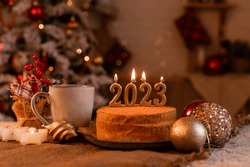 homemade honey cake in the kitchen with candles 2023. Cozy New Year at home. Merry Christmas. High quality photo