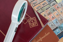 Philatelic Hobby,stamps collecting,stamps albums,tweezer and a loupe,selective focus