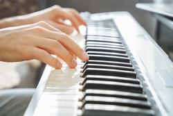 Close-up of male hands playing the electric piano. Background.